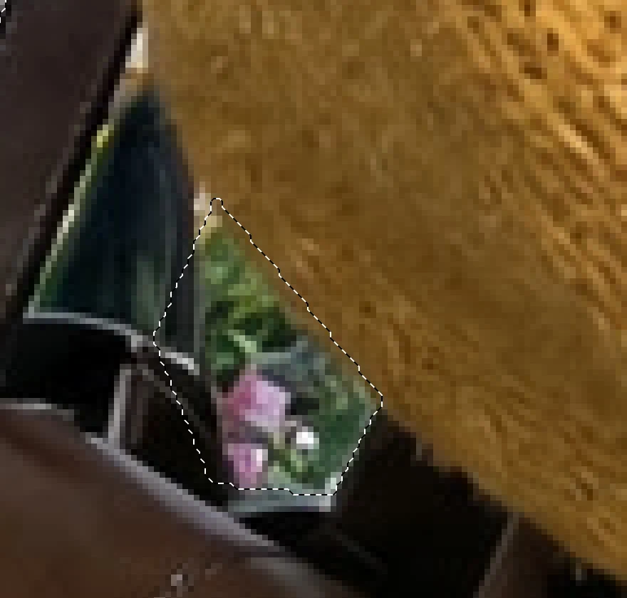Un primo piano dello spazio tra la tracolla della borsa e il braccio, con un contorno tratteggiato intorno ai fiori rosa che si vedono attraverso
