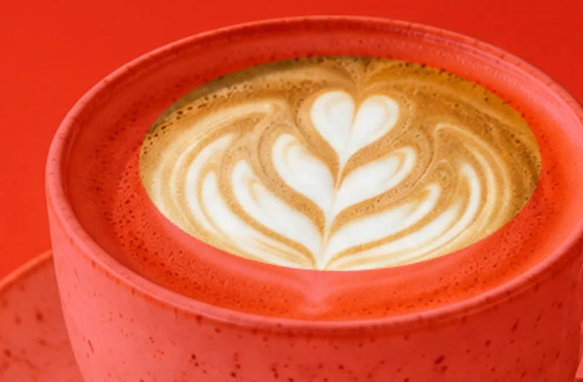 La maschera veloce con il rosso che copre la tazza e la punta inferiore del gambo del latte art fuori dall’ovale