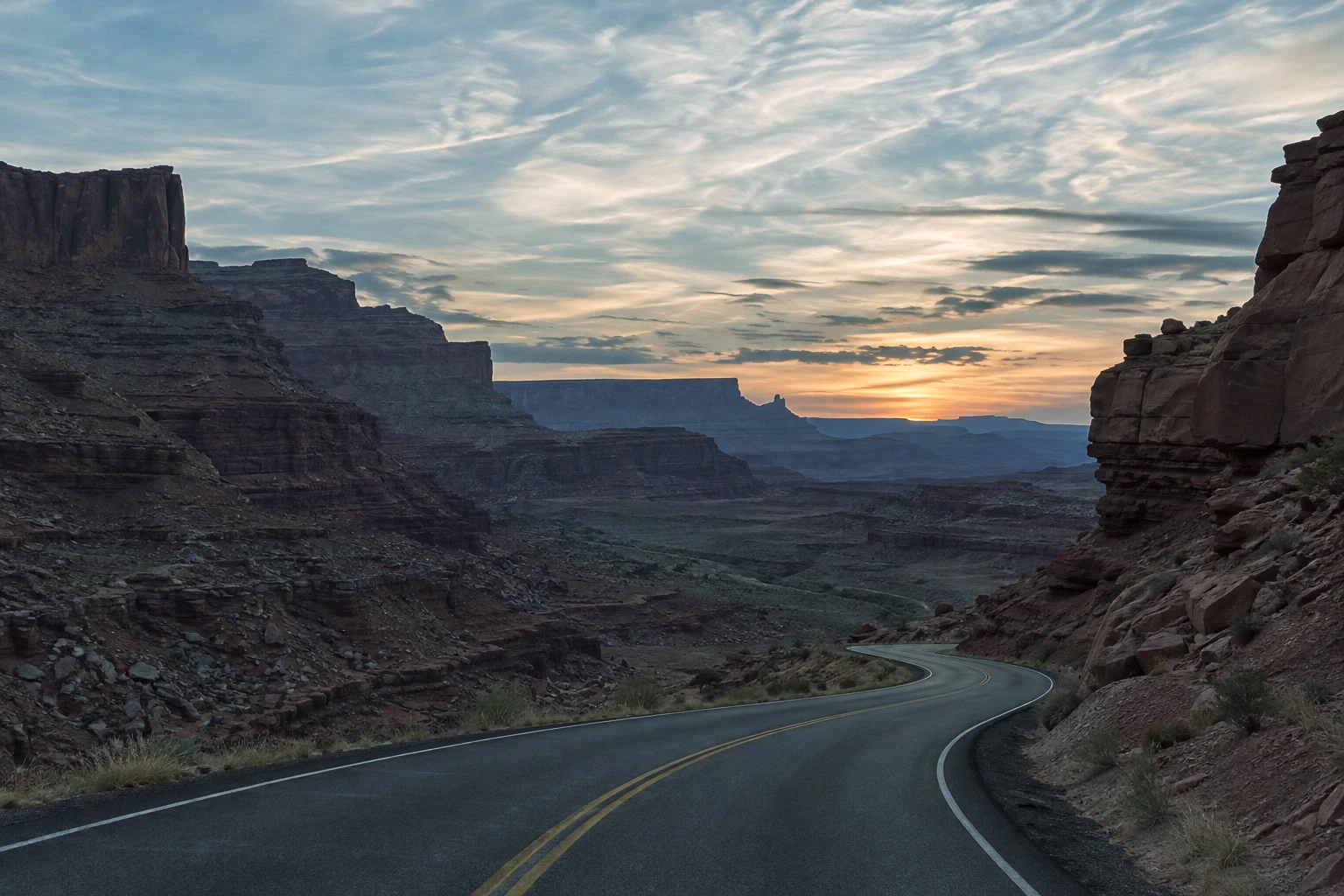 Una strada in un canyon prima e dopo un color grading con contrasto più profondo, toni scuri più freddi e calda luce del tramonto