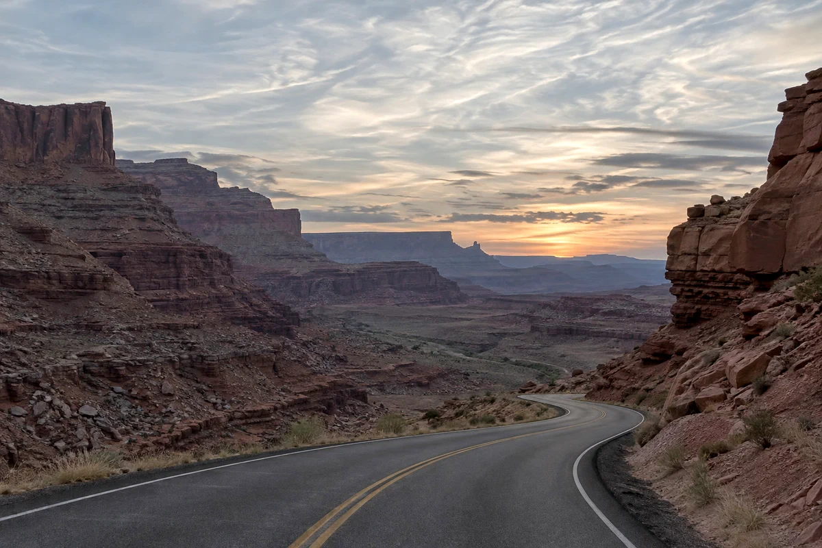 Una strada in un canyon al tramonto: spenta e grigia prima, poi più luminosa, con ombre più profonde e nuvole più pulite dopo Valori tonali