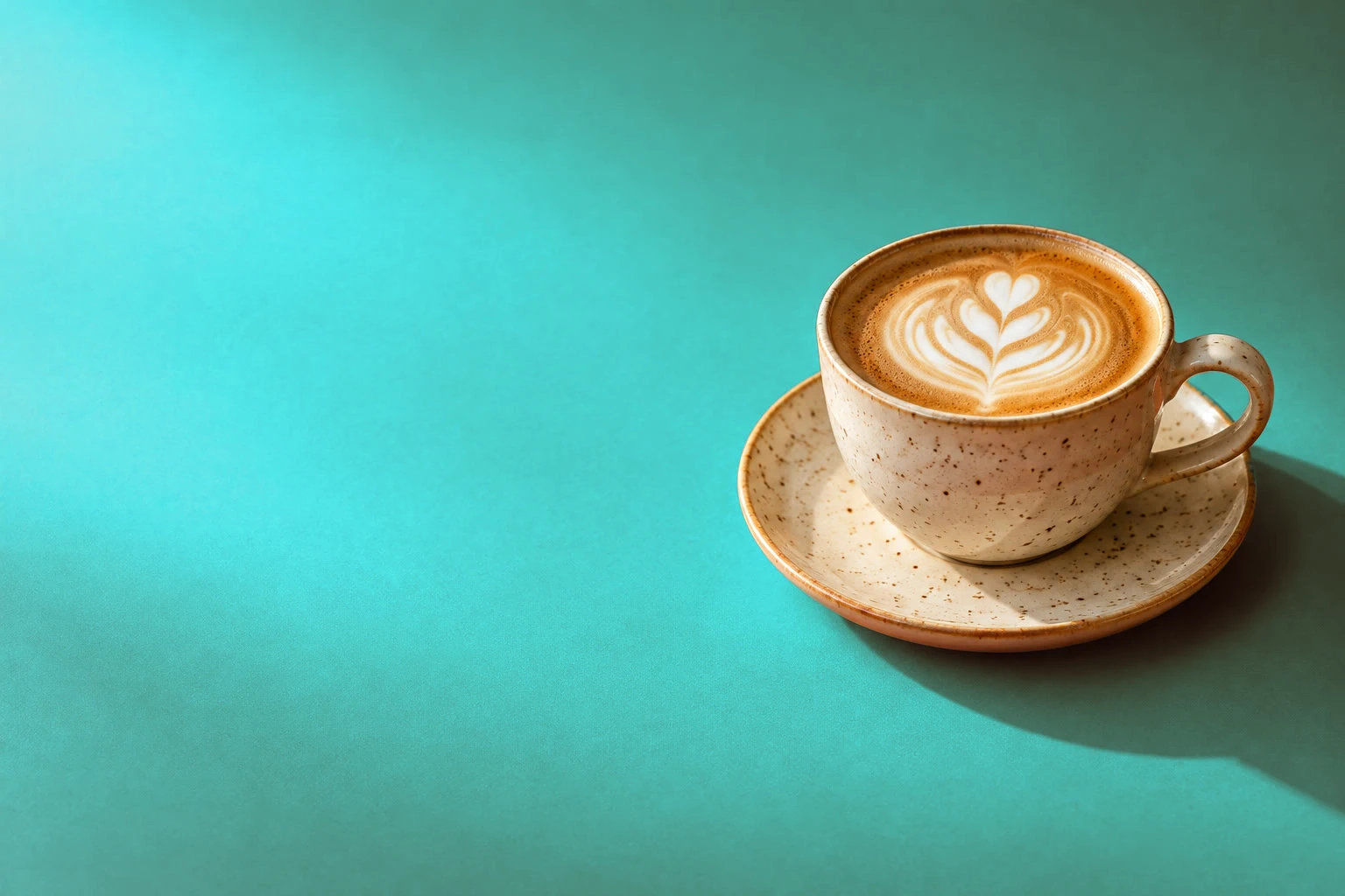 La foto del caffè prima e dopo il passaggio della carta arancione al verde acqua, con la tazza e la latte art che mantengono i loro toni caldi