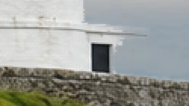 La base del faro ingrandita prima della riparazione della maschera, con il cielo che invade la parete bianca a destra