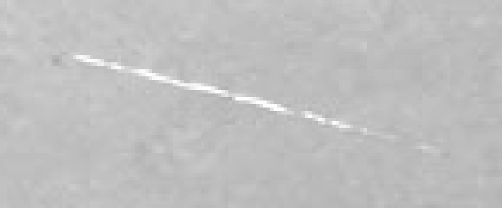 Il graffio bianco inclinato nel cielo in alto a sinistra, ingrandito, prima della riparazione